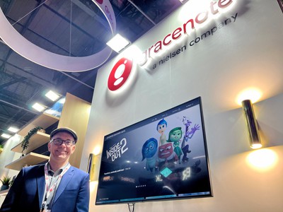 Trent Williams on the Gracenote stand next to a screen with an illuminated Gracenote logo above it